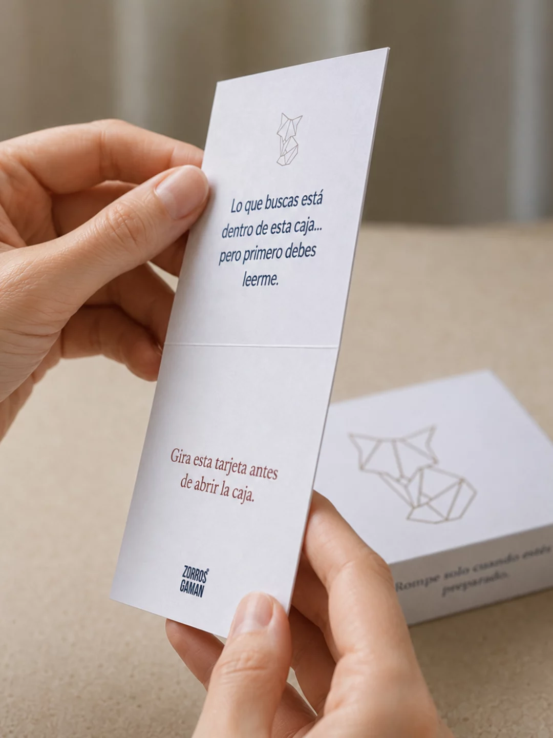 Manos sosteniendo la tarjeta que se lee antes de abrir la caja